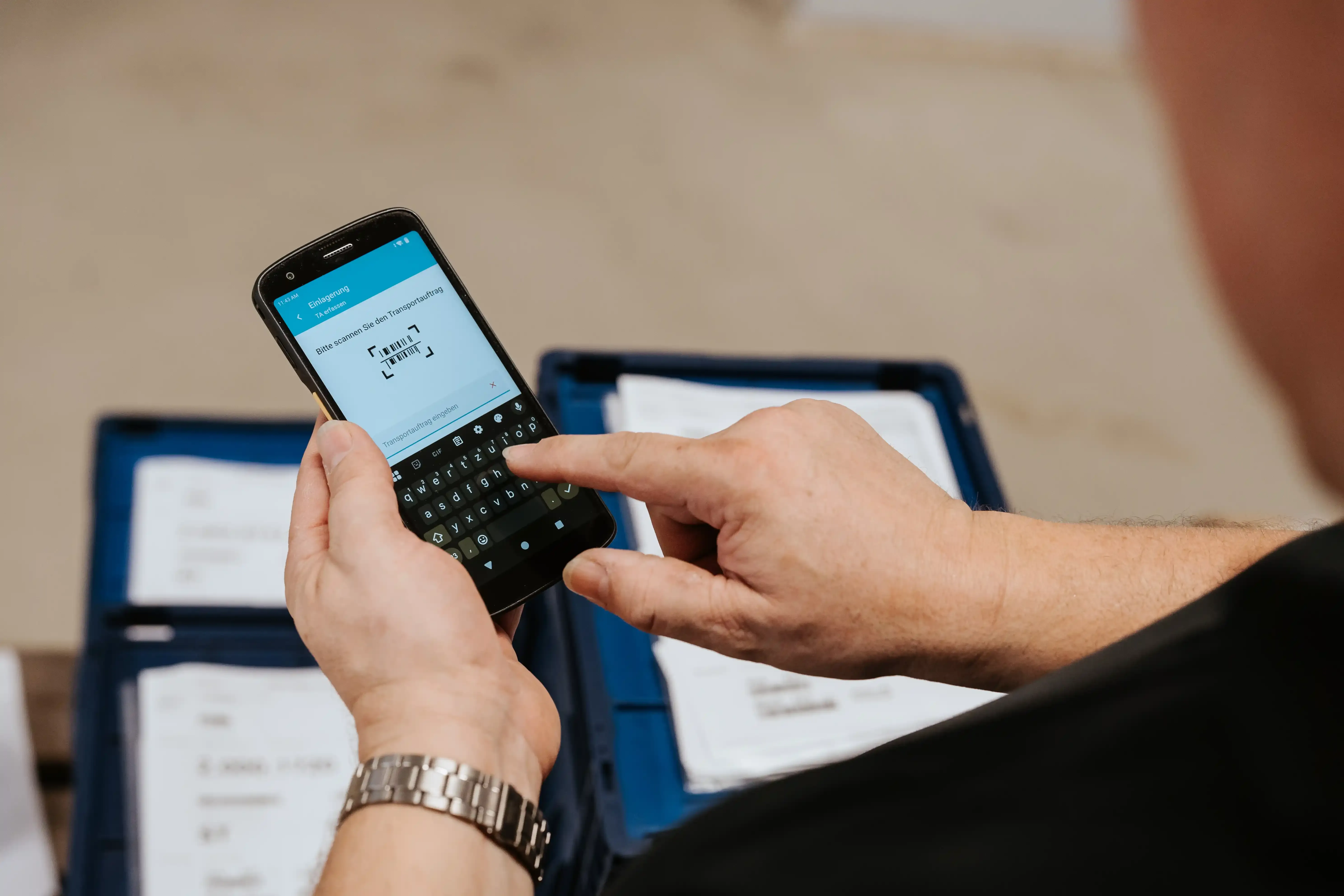 Warehouse operative using the Ontego scanner app on a handheld device to scan a transfer order.